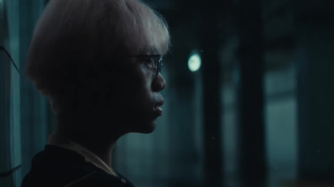 A soft side-profile of a player lit by ambient blue tones. The still captures vulnerability and focus, mid-narrative, in a minimal, moody frame.